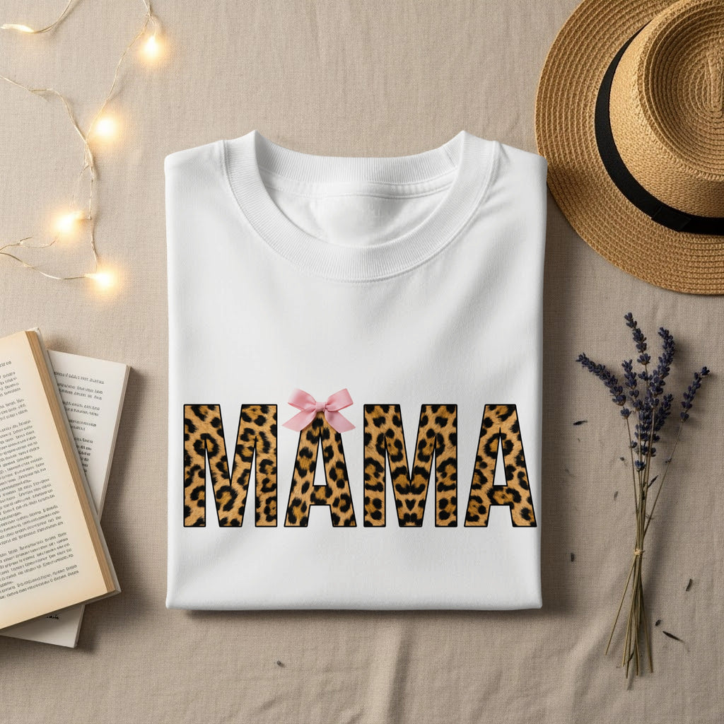 White t-shirt with "MAMA" in leopard print and pink bow.