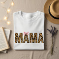 White t-shirt with "MAMA" in leopard print and pink bow.