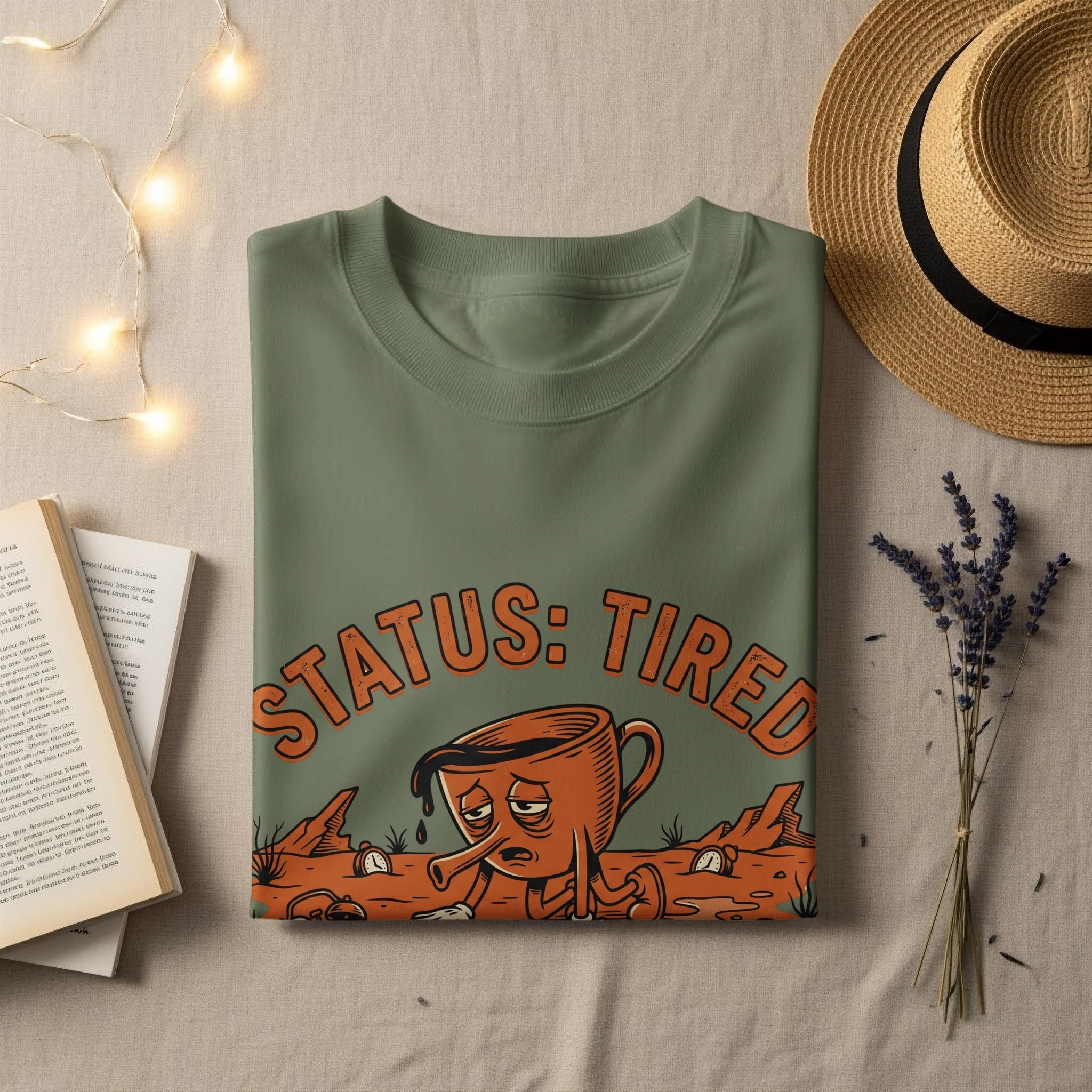 Olive green t-shirt with "STATUS: TIRED" text and cartoon coffee cup.