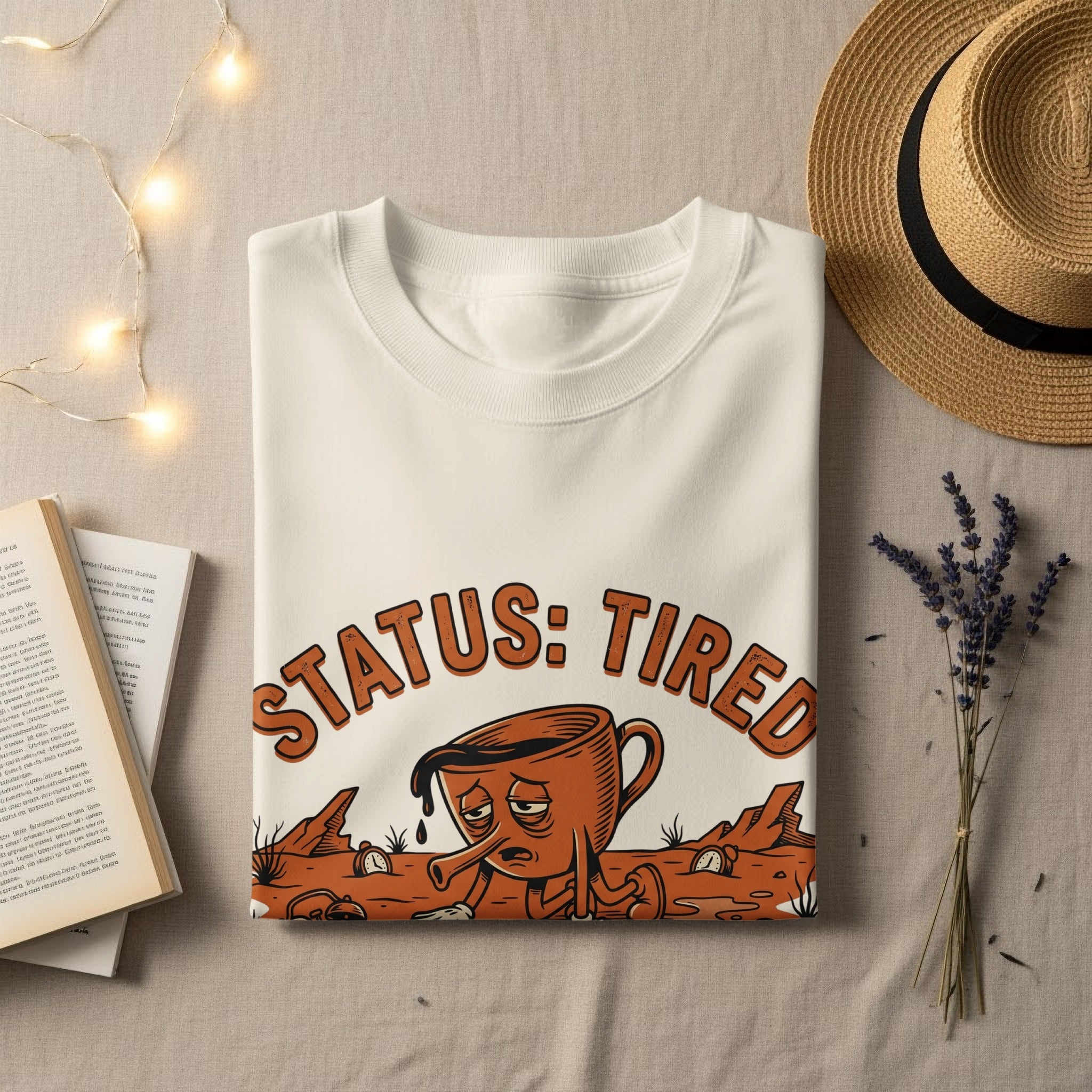 White t-shirt with "STATUS: TIRED" text and a sad coffee cup graphic.
