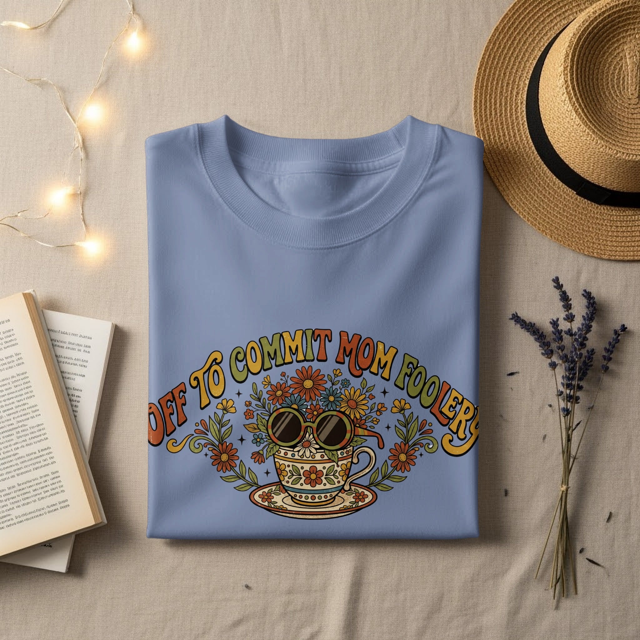 Blue t-shirt with "Off to commit mom foolishness" text and floral sunglasses.