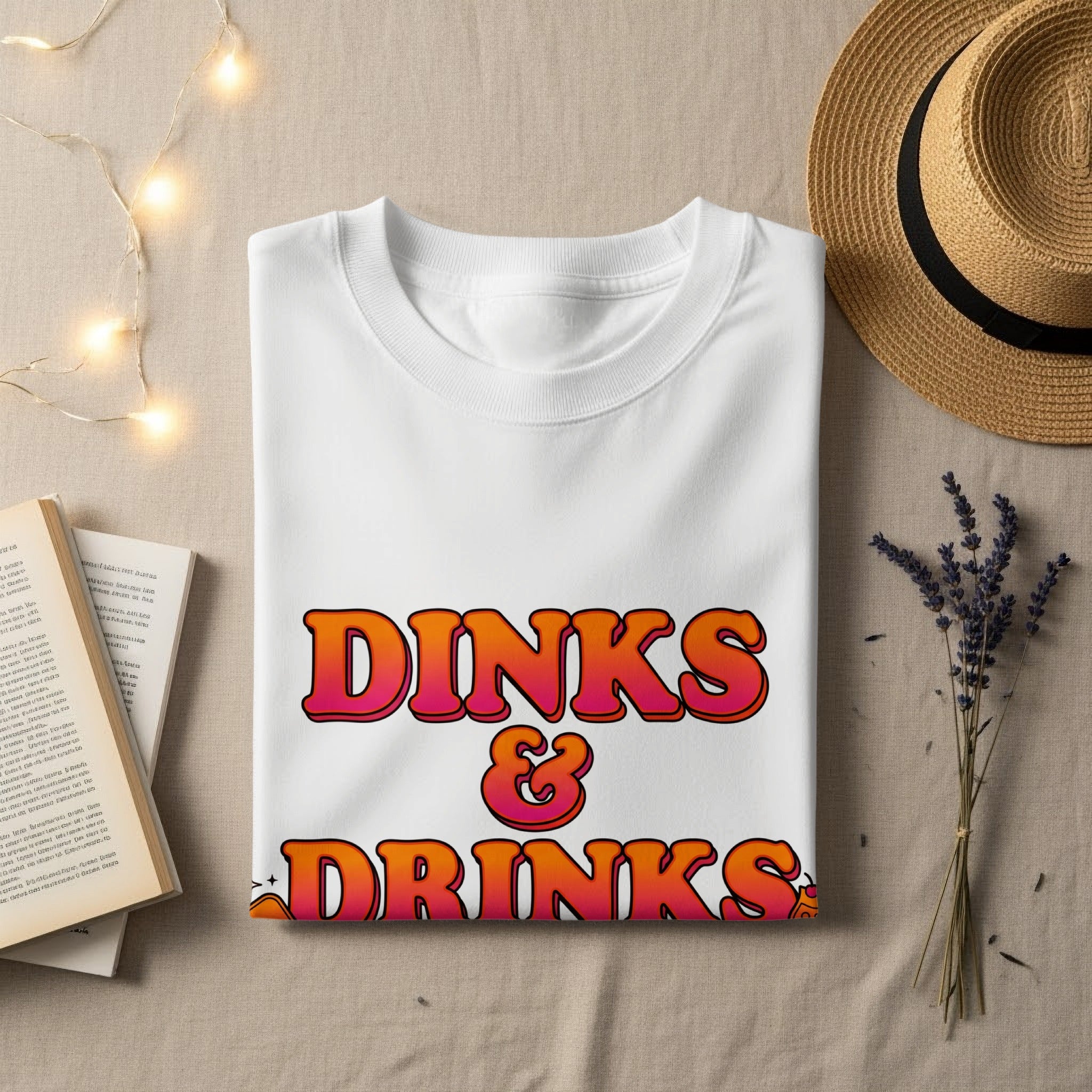 White t-shirt with "DINKS & DRINKS" in colorful, retro text.