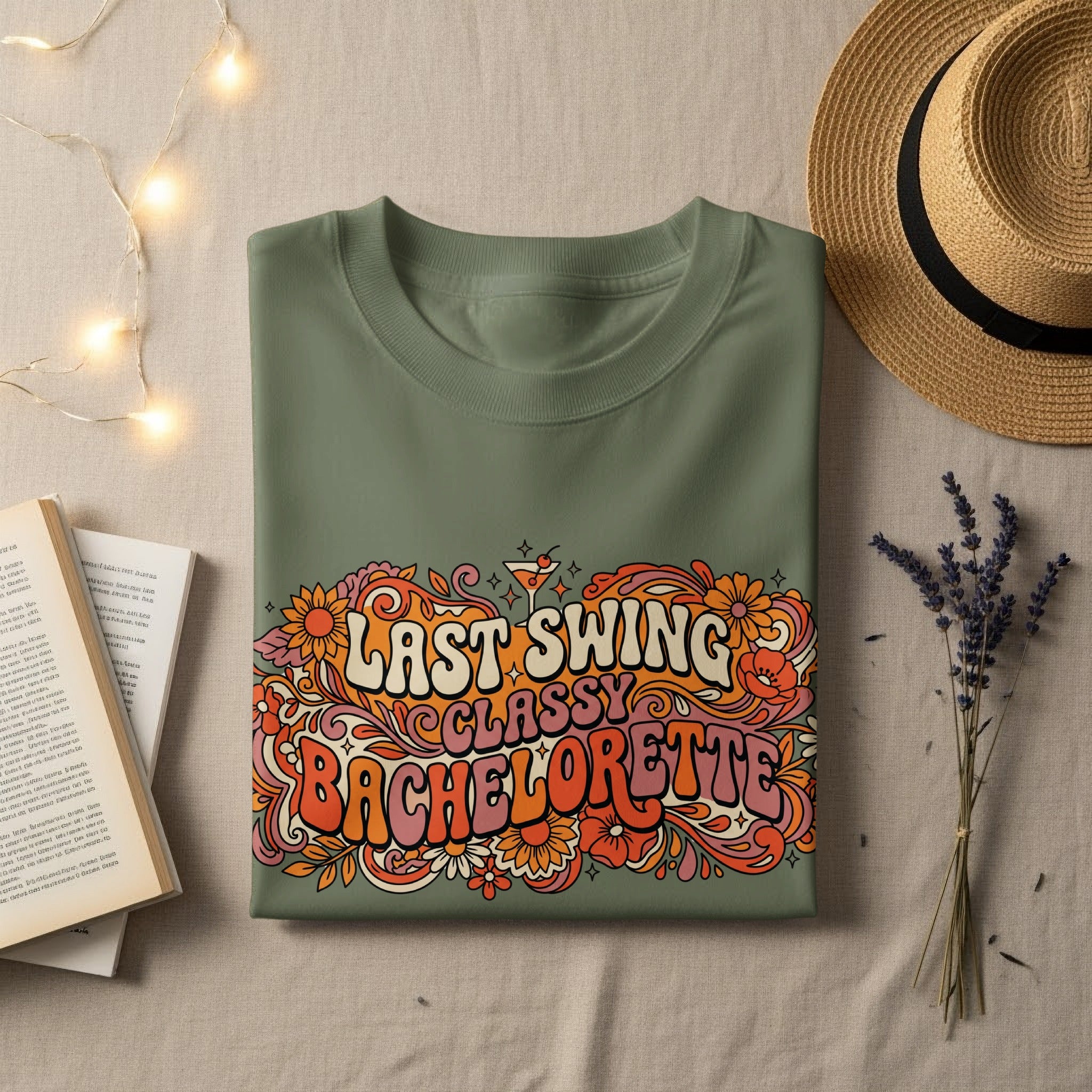Olive green t-shirt with "Last Swing Bachelorette" text in colorful floral design.