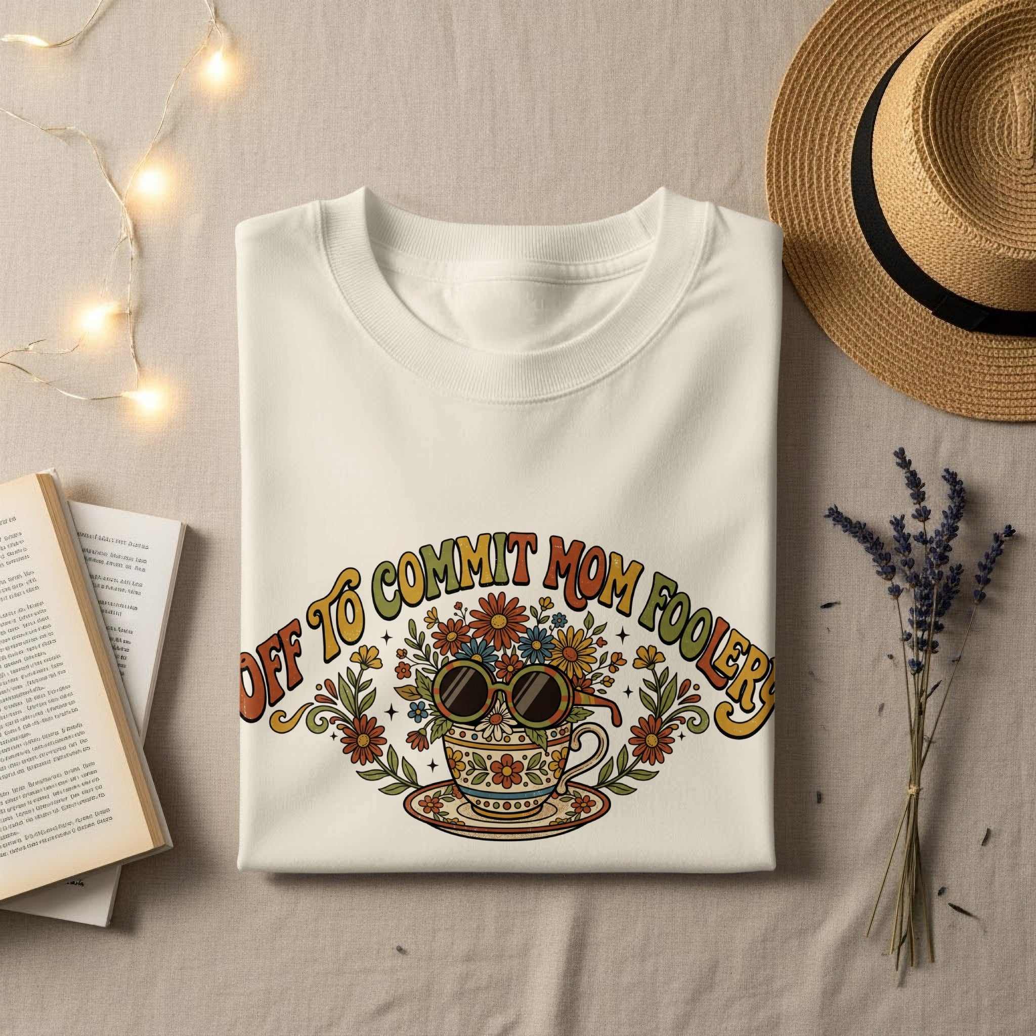 T-shirt with "Off to commit mom-foolers" text and floral mug graphic.