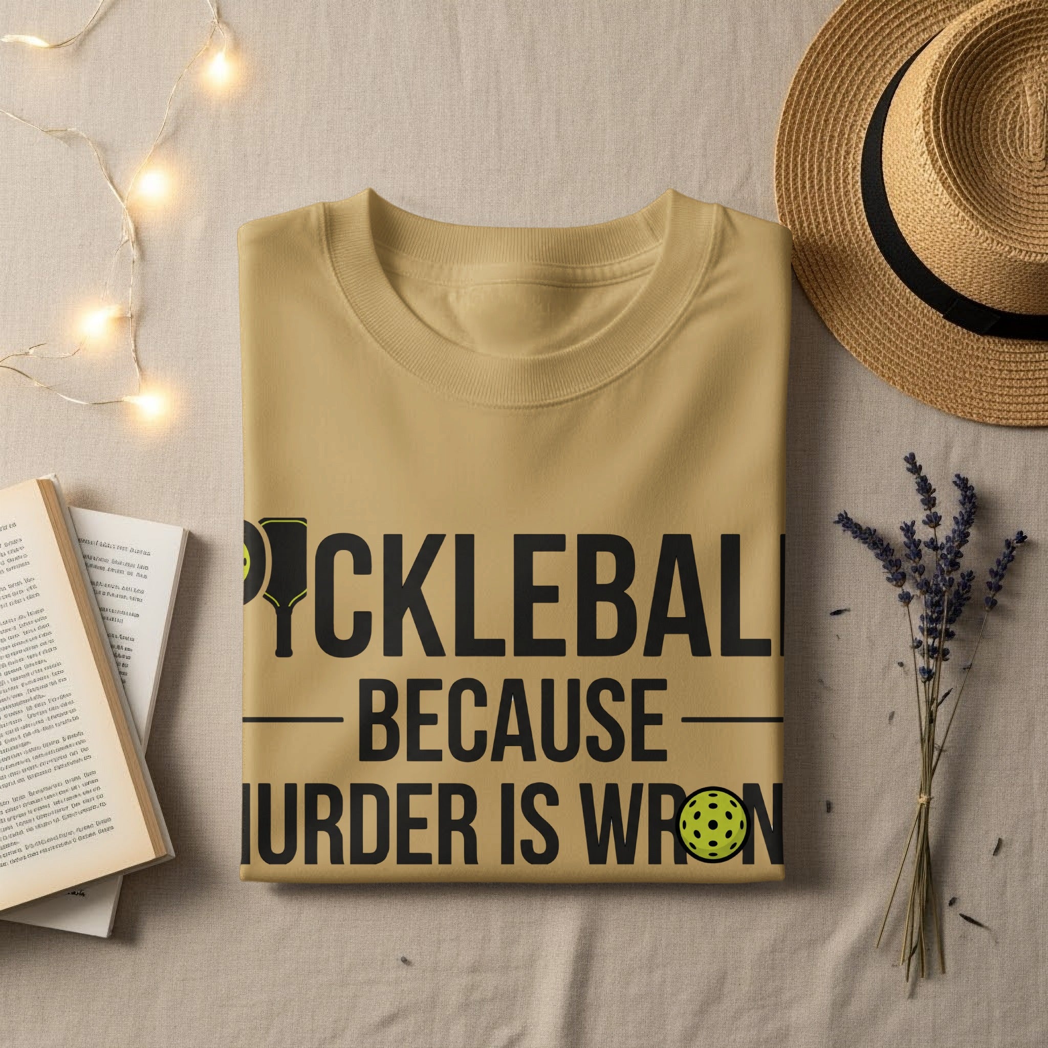 Tan t-shirt with "Pickleball Because Murder is Wrong" text and pickleball graphic.