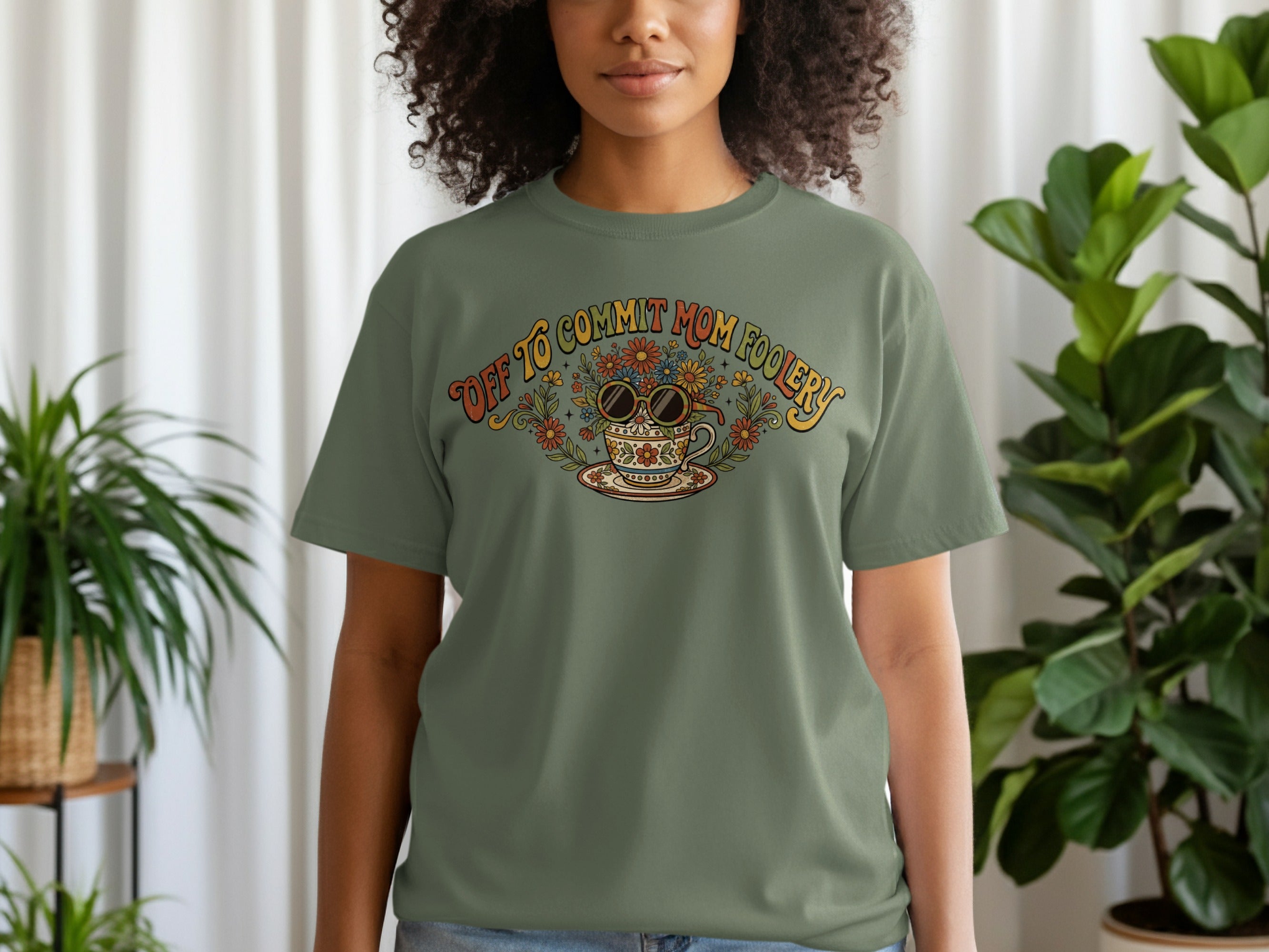 Olive green t-shirt with floral teacup graphic and "Off to Commit Mom Foolery" text.