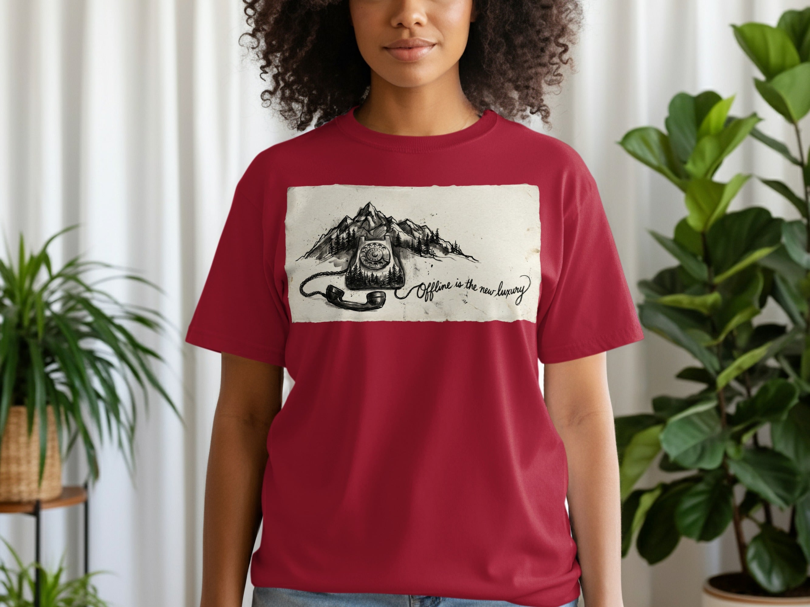 Maroon t-shirt with a sketched vintage rotary phone and mountains with text "Offline is the new luxury".