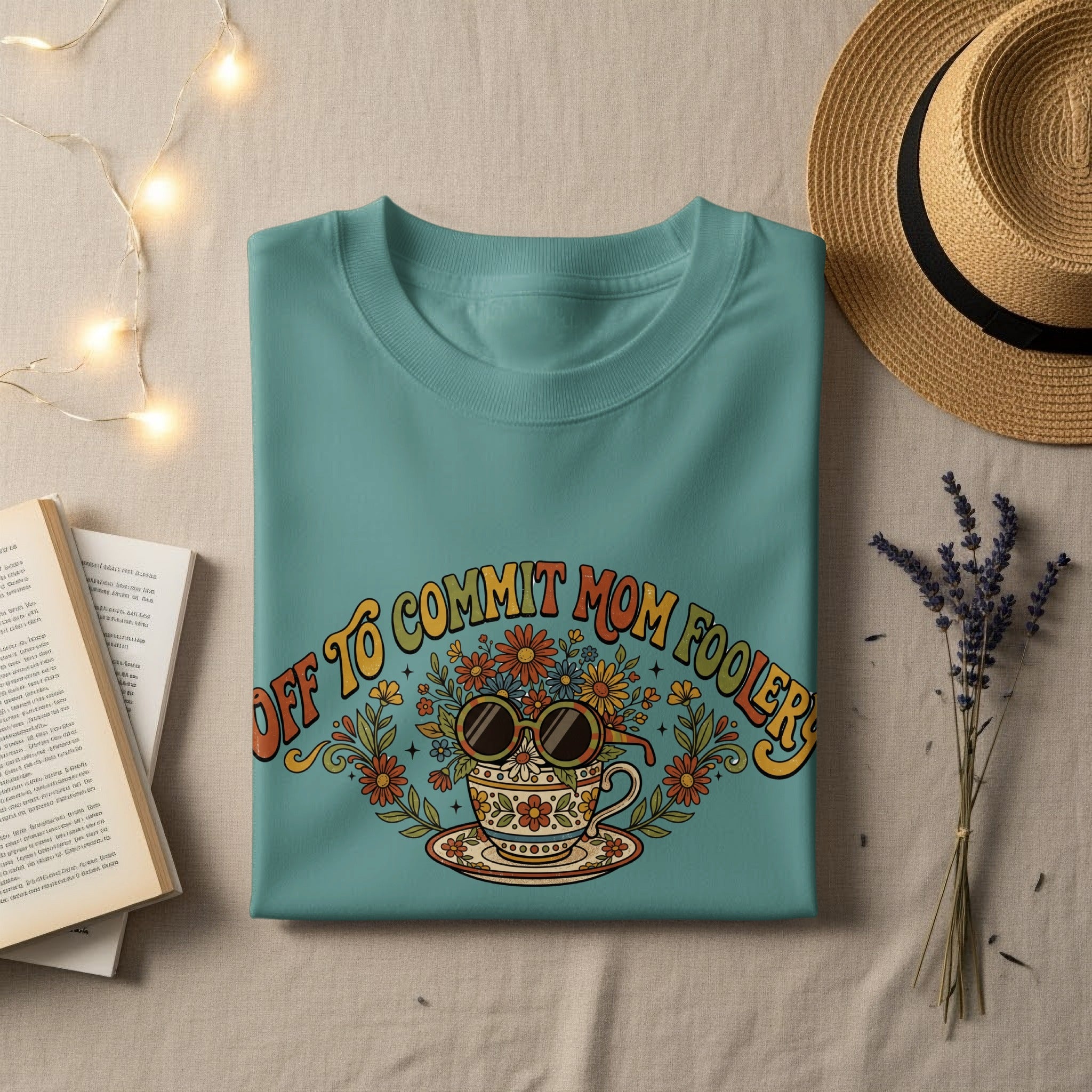 Teal t-shirt with "Off to commit mom foolery" text and floral sunglasses.