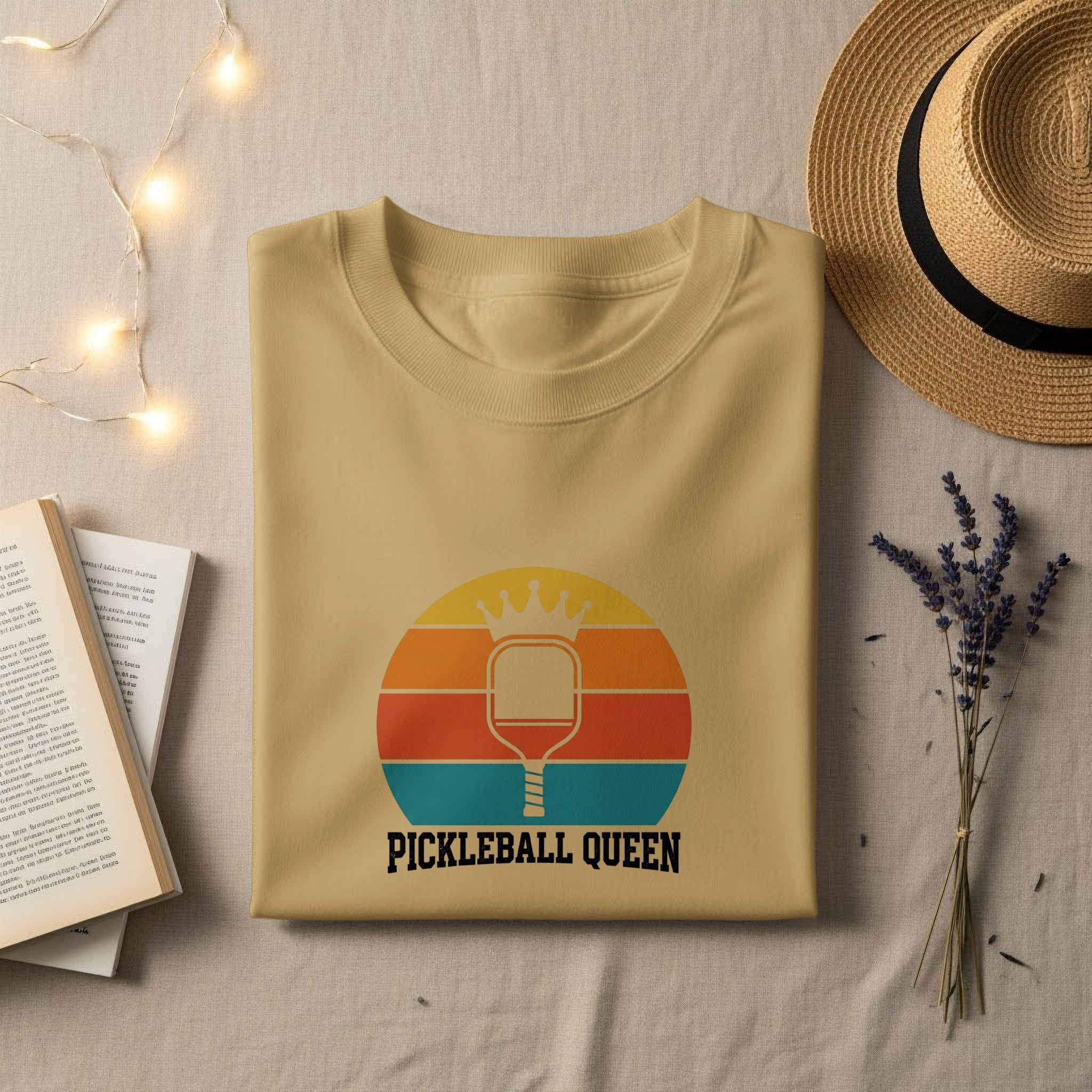 Cream t-shirt with "PICKLEBALL QUEEN" text and retro pickleball paddle graphic.