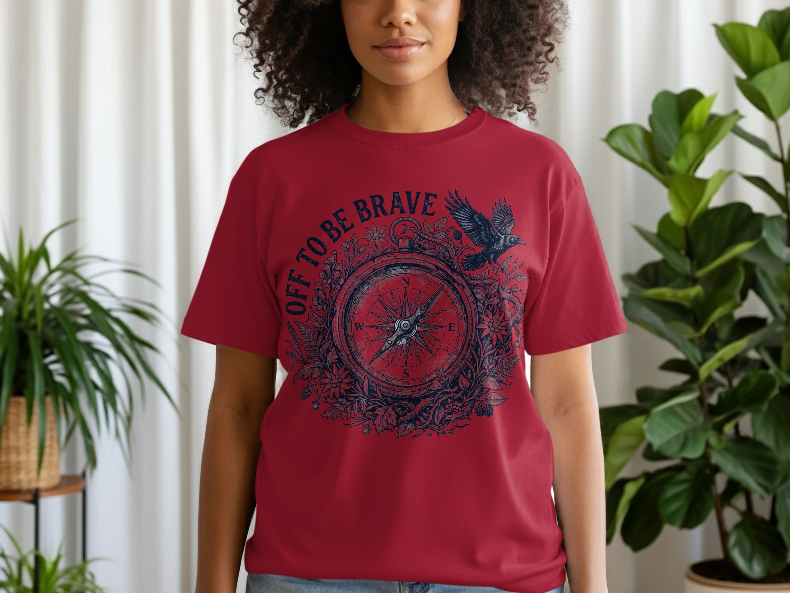 Red t-shirt with compass graphic and "Off to be Brave" text.