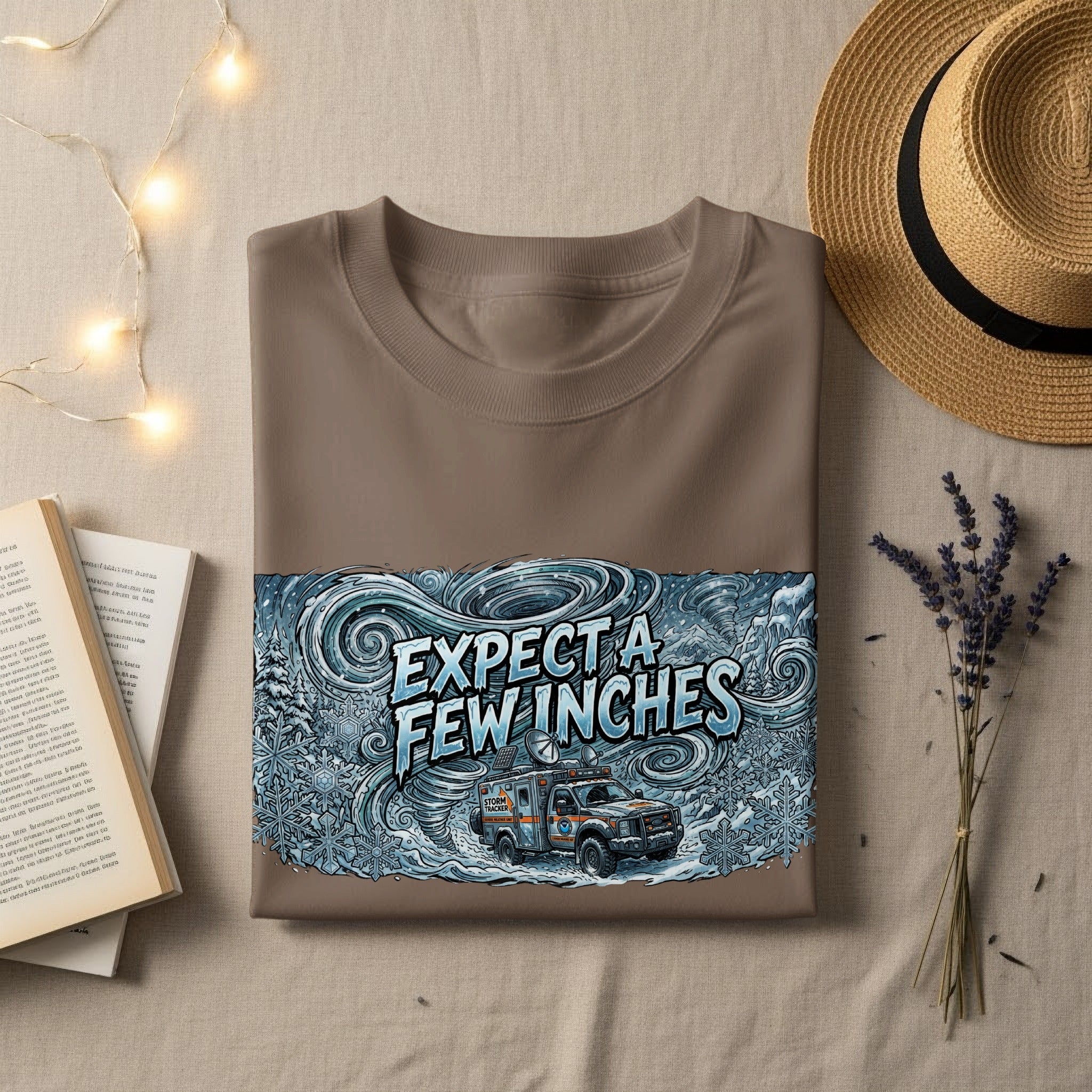 Brown t-shirt with "EXPECT A FEW INCHES" and a storm tracker vehicle illustration.