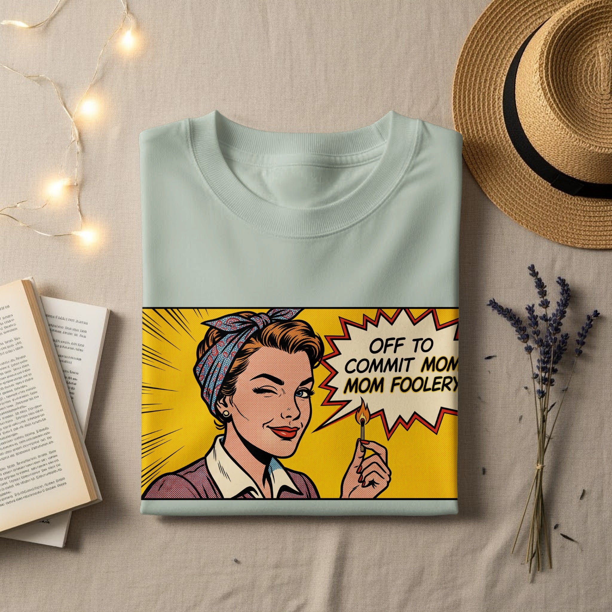 Light blue t-shirt with comic-style graphic of a woman holding a lit match and winking.