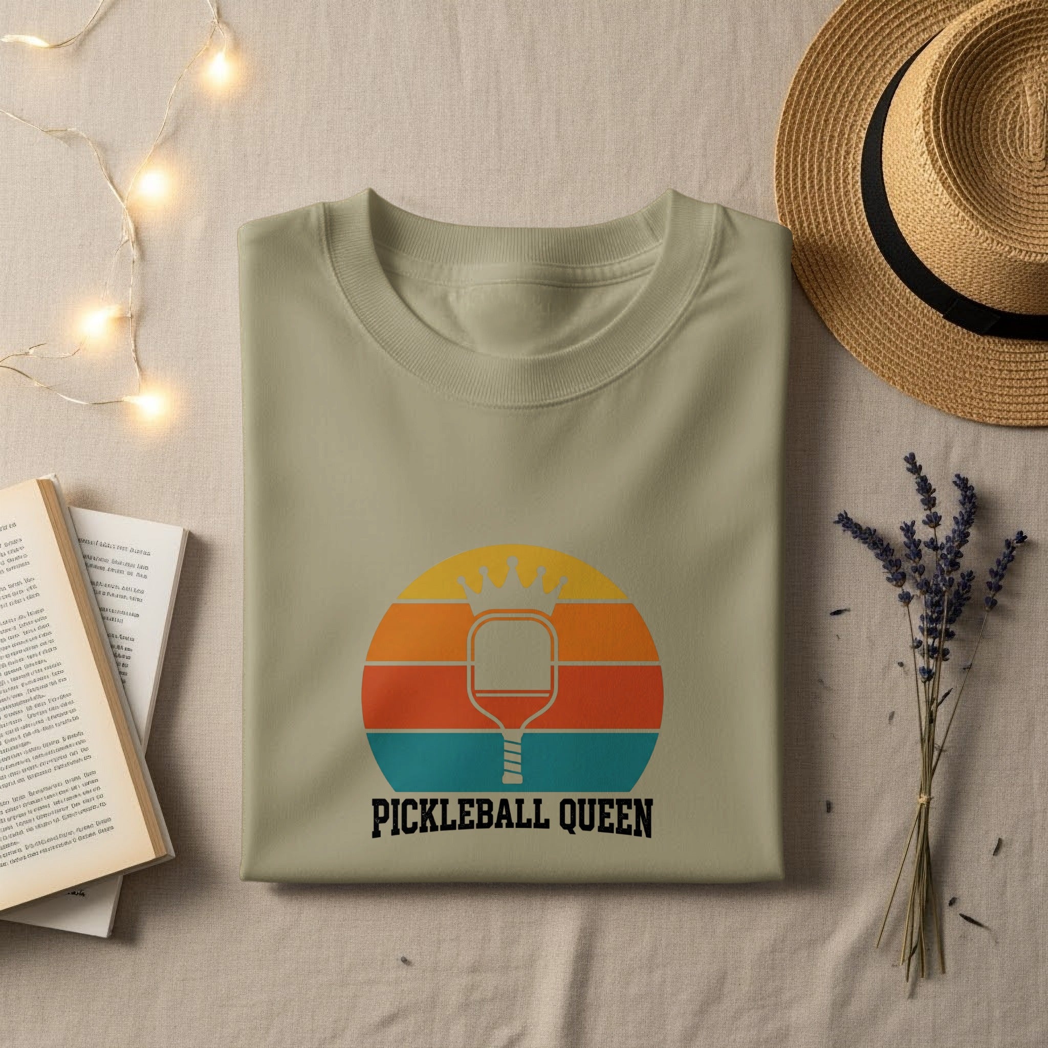 Light tan t-shirt with a retro pickleball graphic and text: PICKLEBALL QUEEN.