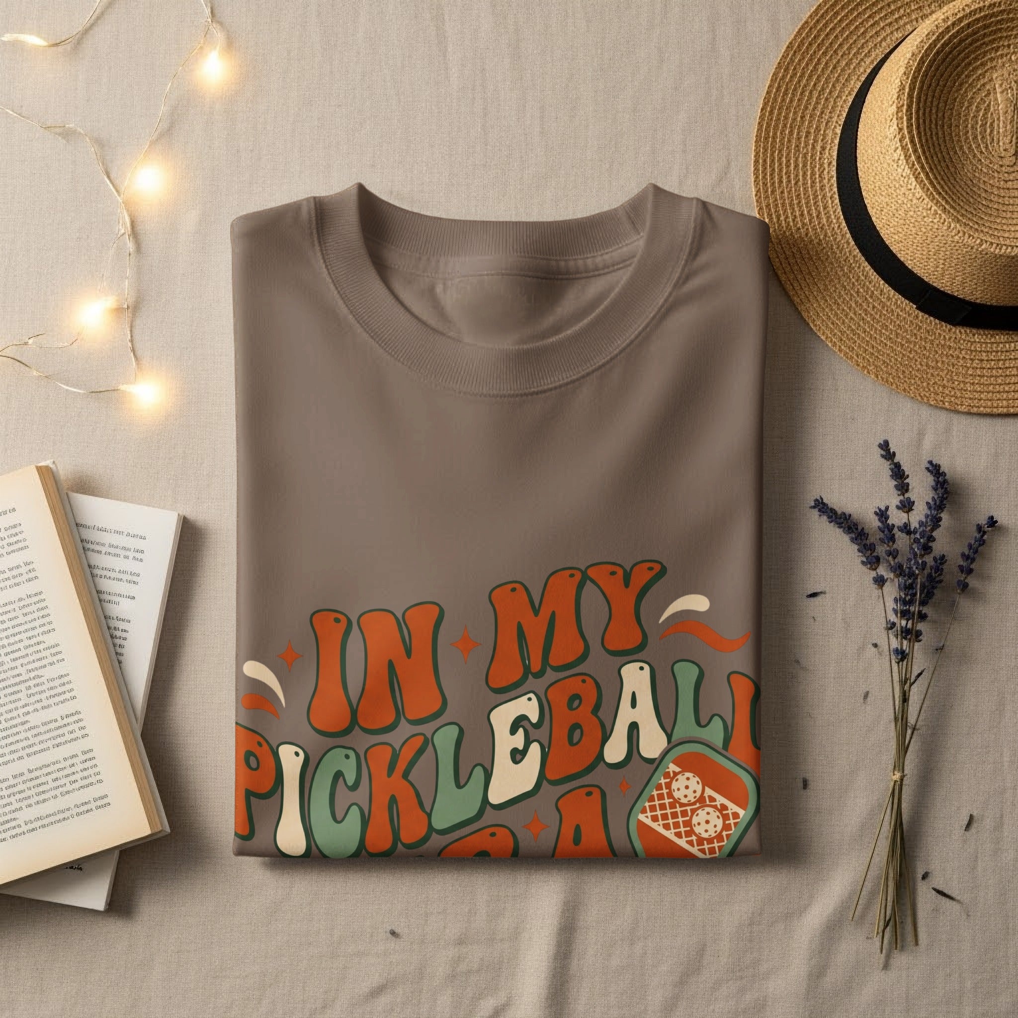 Brown t-shirt with "In My Pickleball Era" text and pickleball graphic.