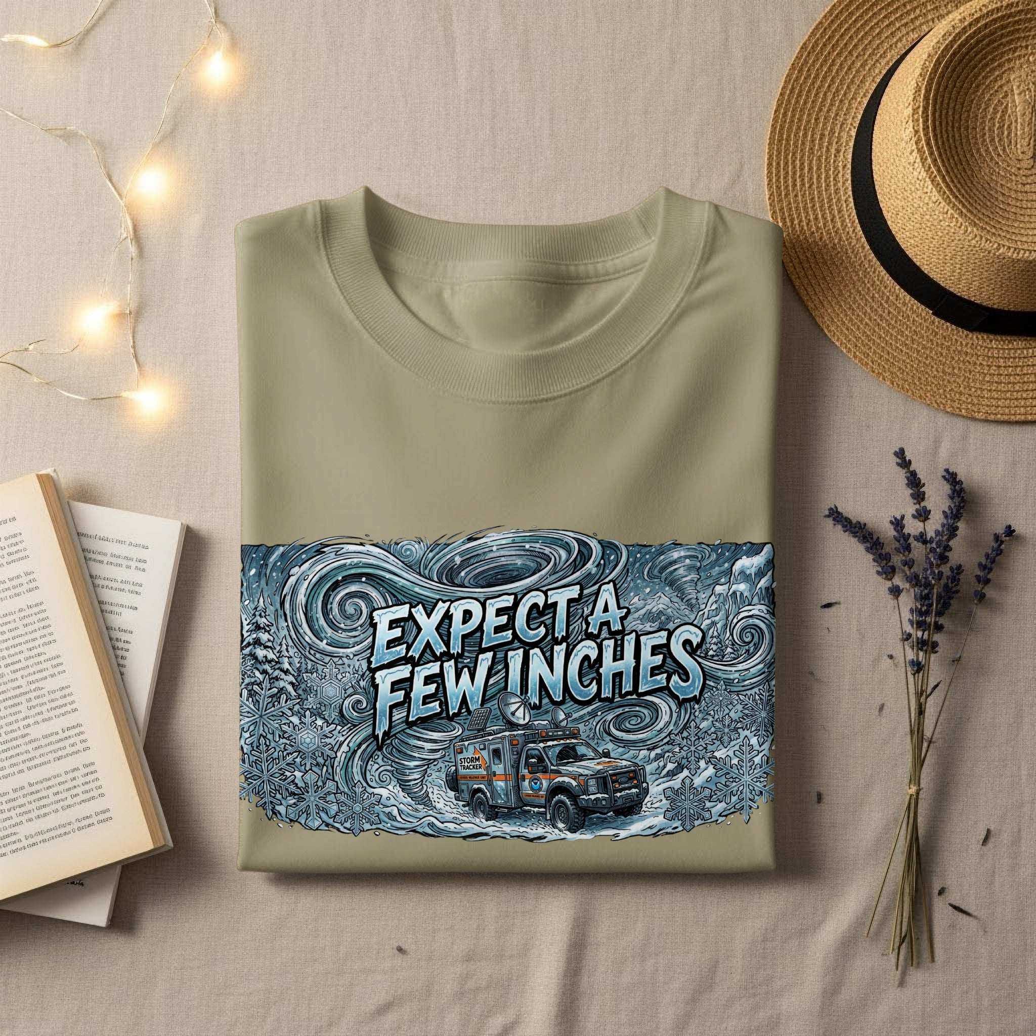 Olive green t-shirt with "EXPECT A FEW INCHES" text and a storm tracker vehicle graphic.