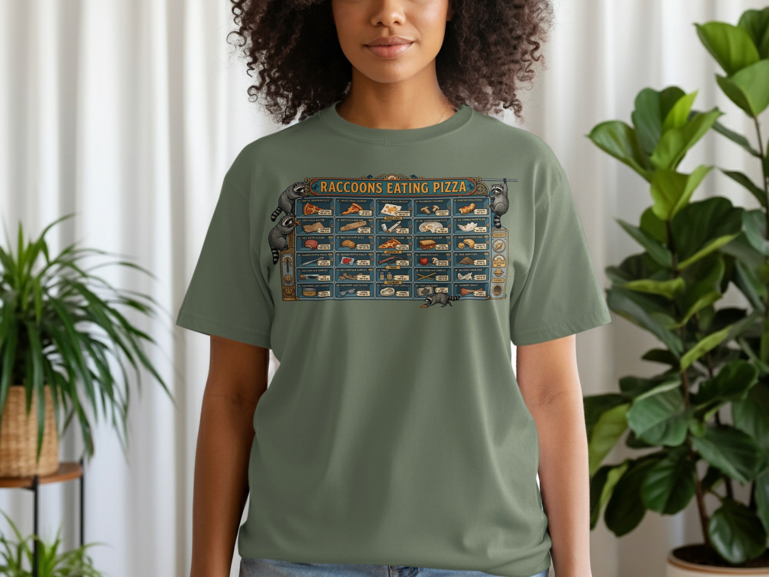 Green t-shirt with illustration of raccoons eating pizza and various pizza-related items.