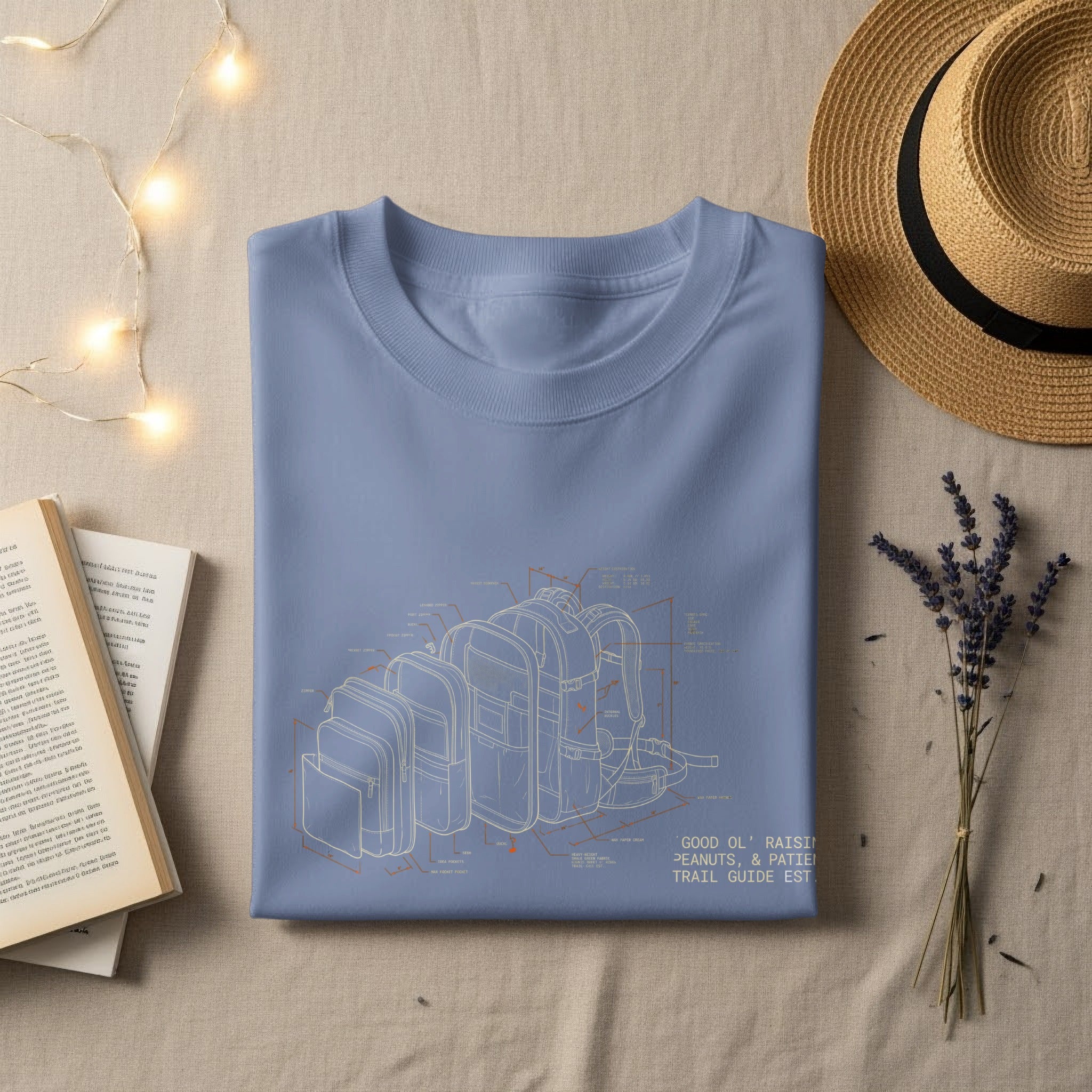 Blue t-shirt with blueprint of a backpack and "GOOD OL' RAISIN PEANUTS, & PATIE TRAIL GUIDE EST." text.