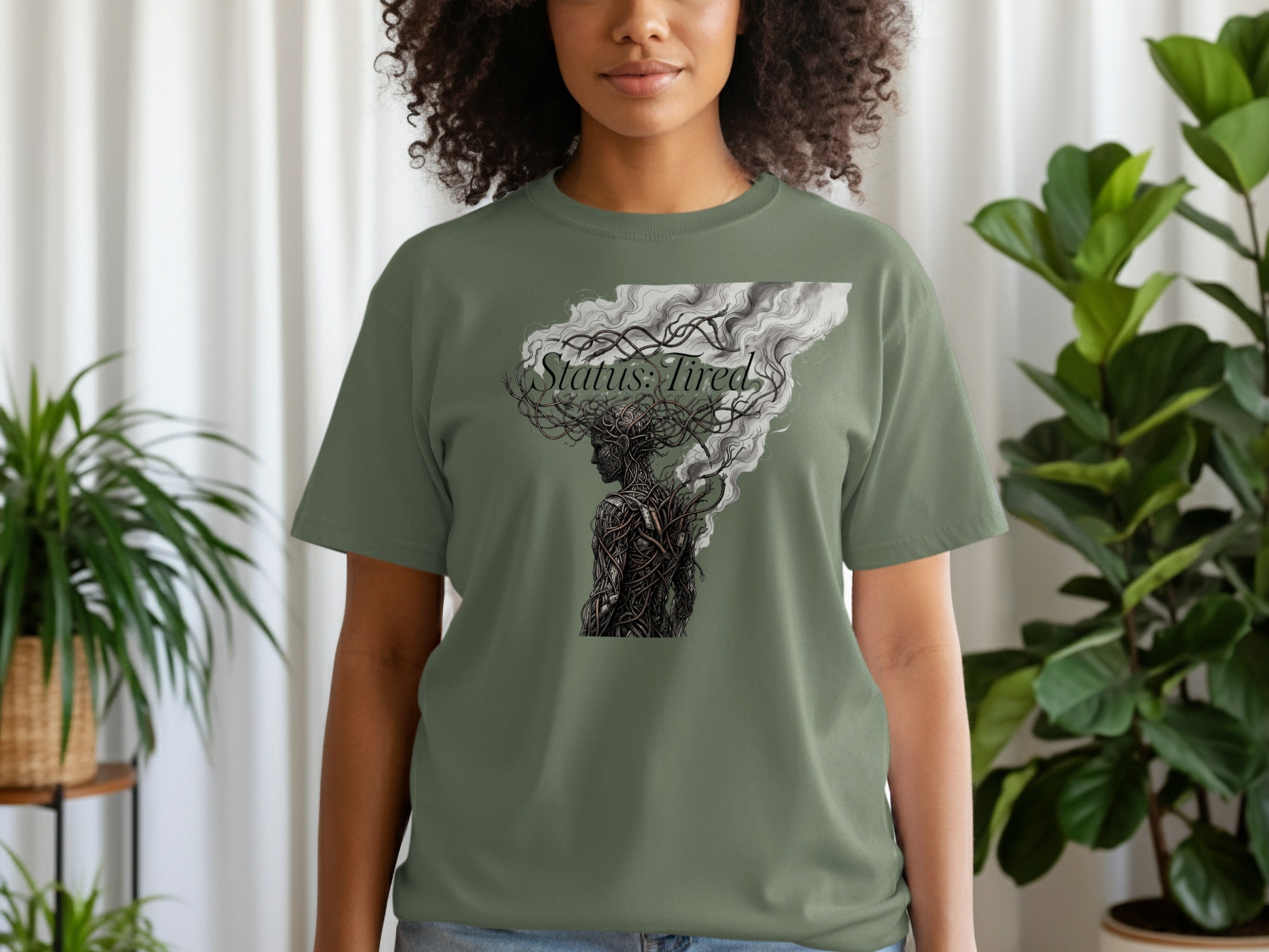 Woman wearing a green t-shirt with "Status: Tired" text and a stylized head illustration.