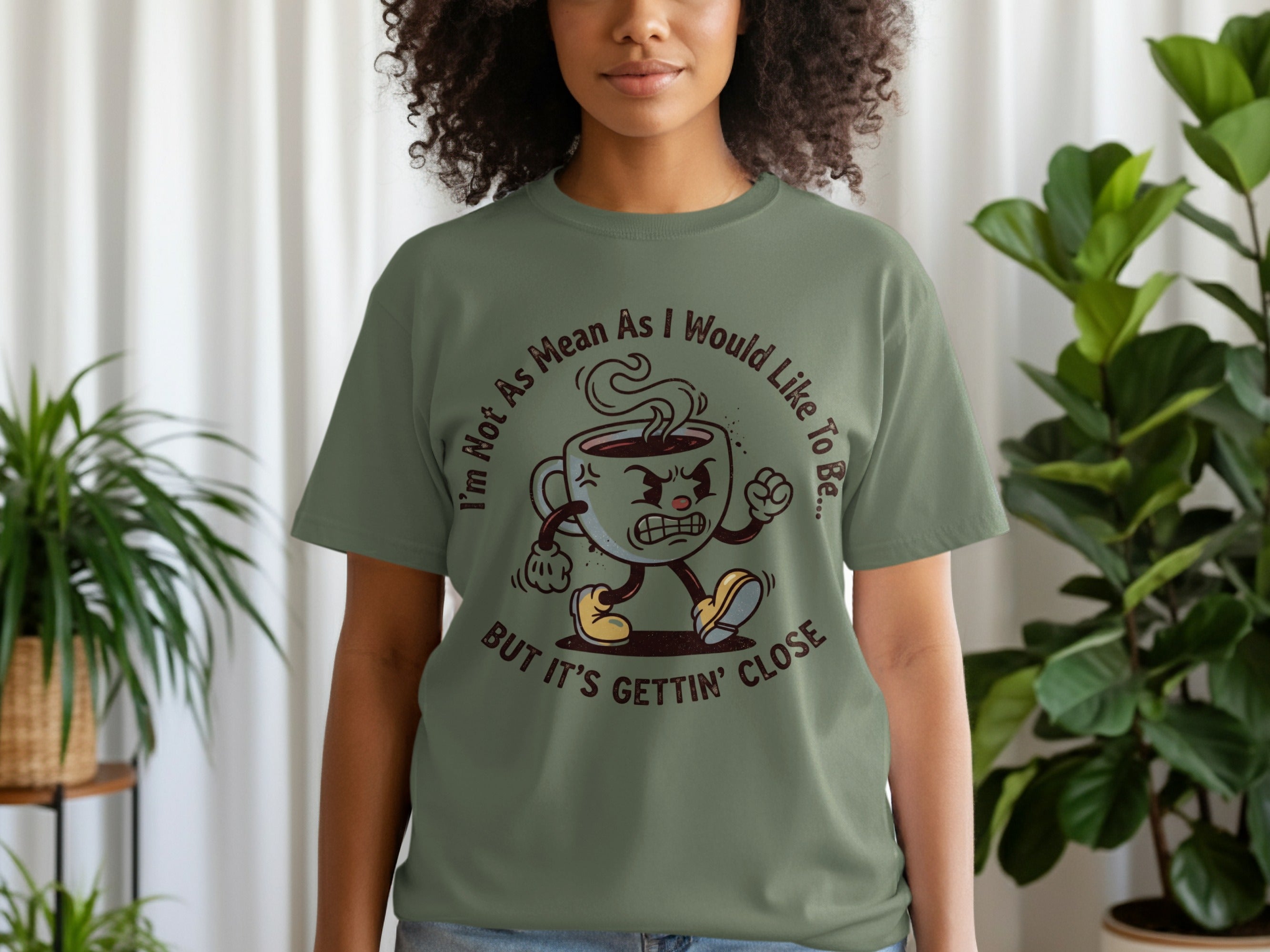 T-shirt with cartoon coffee cup character and text "I'm Not As Mean As I Would Like To Be... BUT IT'S GETTIN' CLOSE".