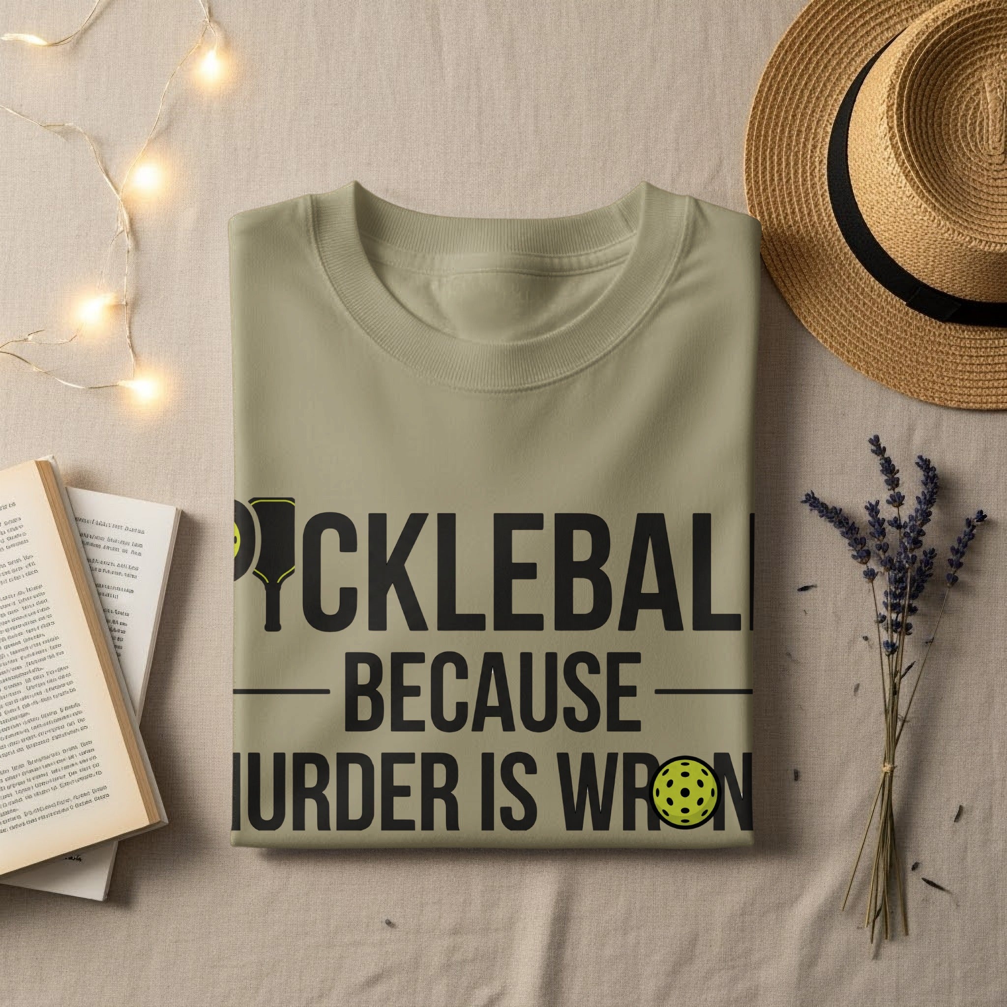Light beige t-shirt with "PICKLEBALL BECAUSE MURDER IS WRONG" text and pickleball graphic.