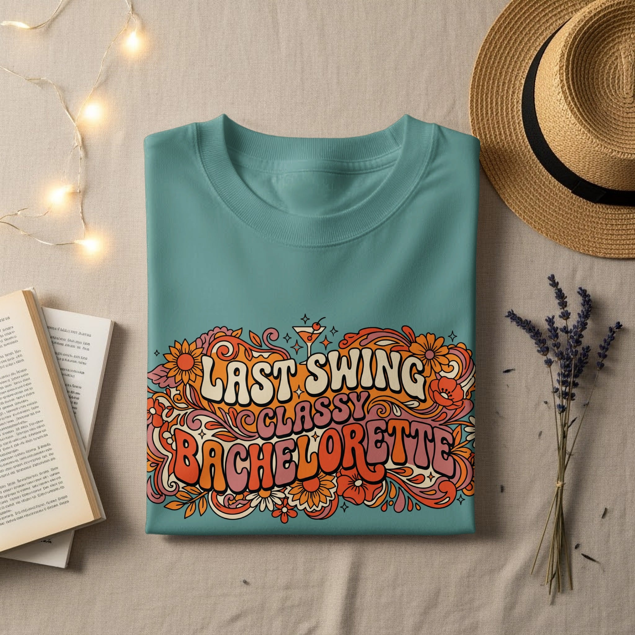 Teal t-shirt with "Last Swing Bachelorette" in floral, retro lettering.