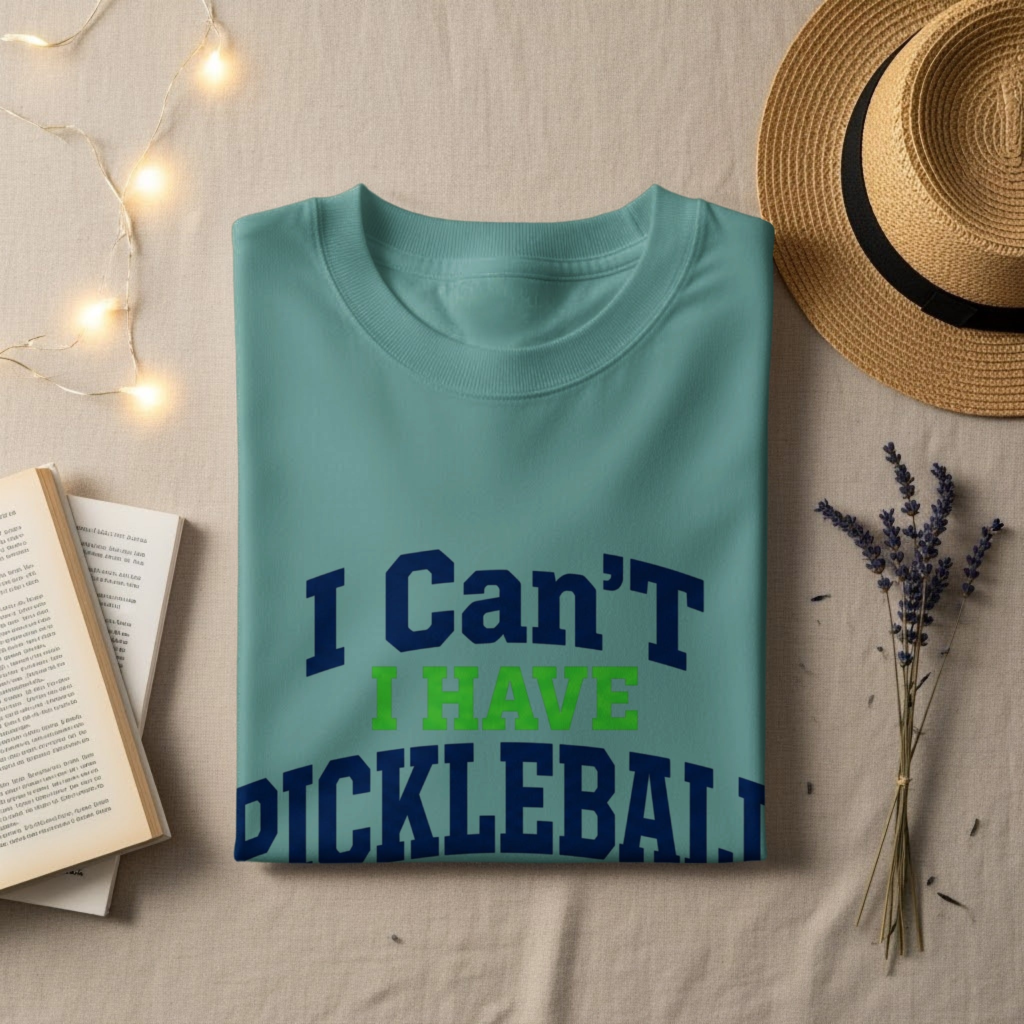 T-shirt with "I Can't I Have Pickleball" text on a light surface.