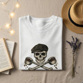 T-shirt with skull wearing a flat cap, holding crossed spoons of coffee beans.