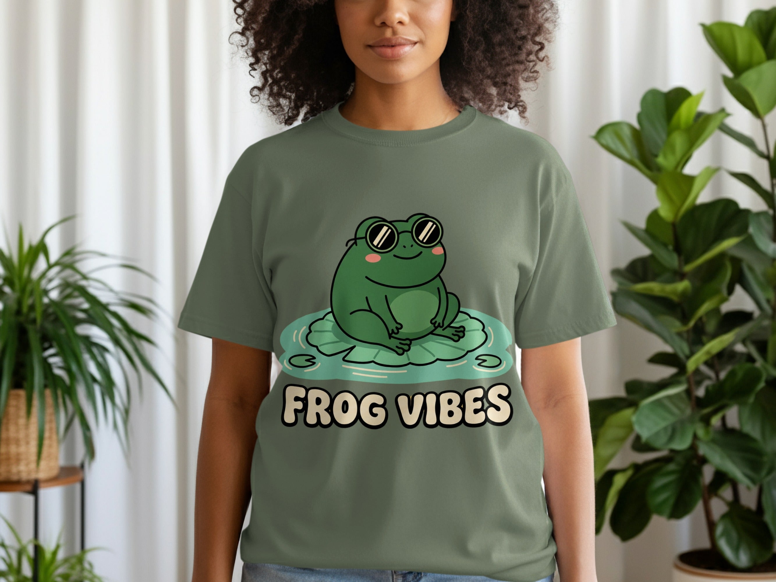 Green t-shirt with a cartoon frog wearing sunglasses on a lily pad.