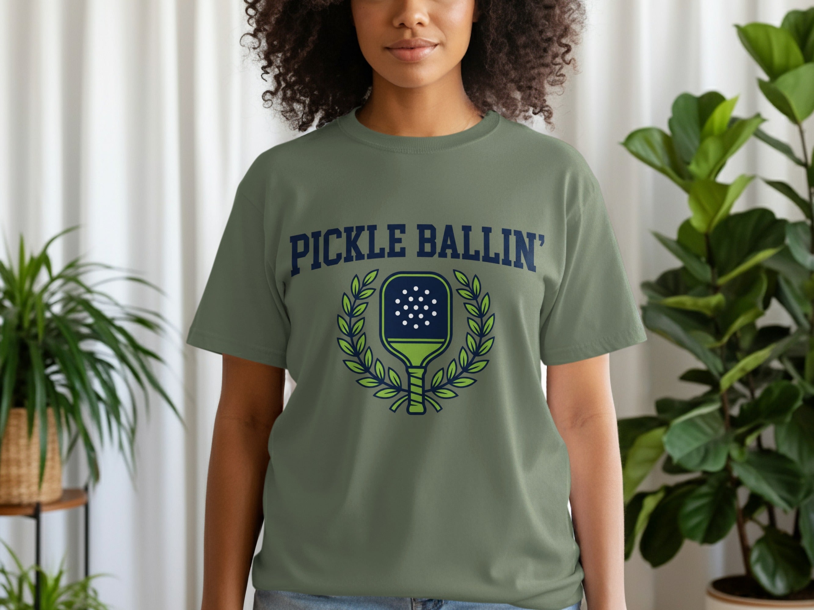 Olive green t-shirt with "PICKLE BALLIN'" text and pickleball paddle graphic.
