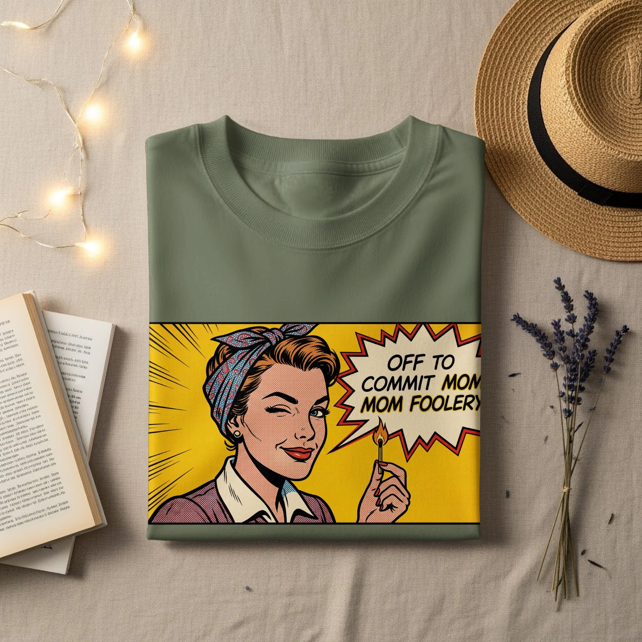 Green t-shirt with comic book style woman winking and holding a lit match, saying "OFF TO COMMIT MOM FOOLERY".
