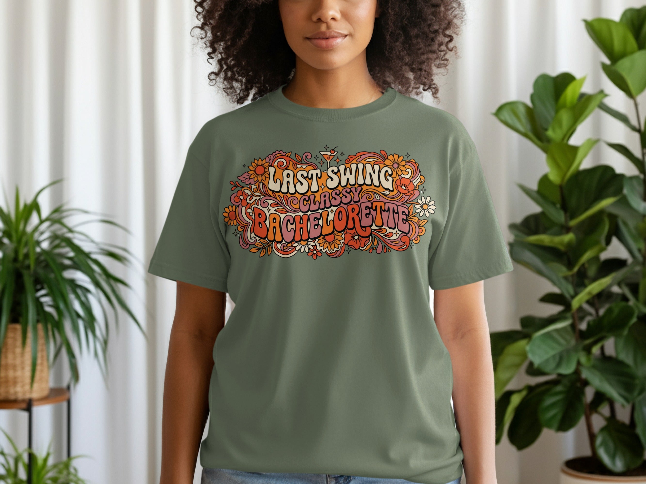 Olive green t-shirt with "Last Swing Bachelorette" text and floral graphics.