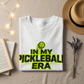 White t-shirt with "In My Pickleball Era" text and graphic.