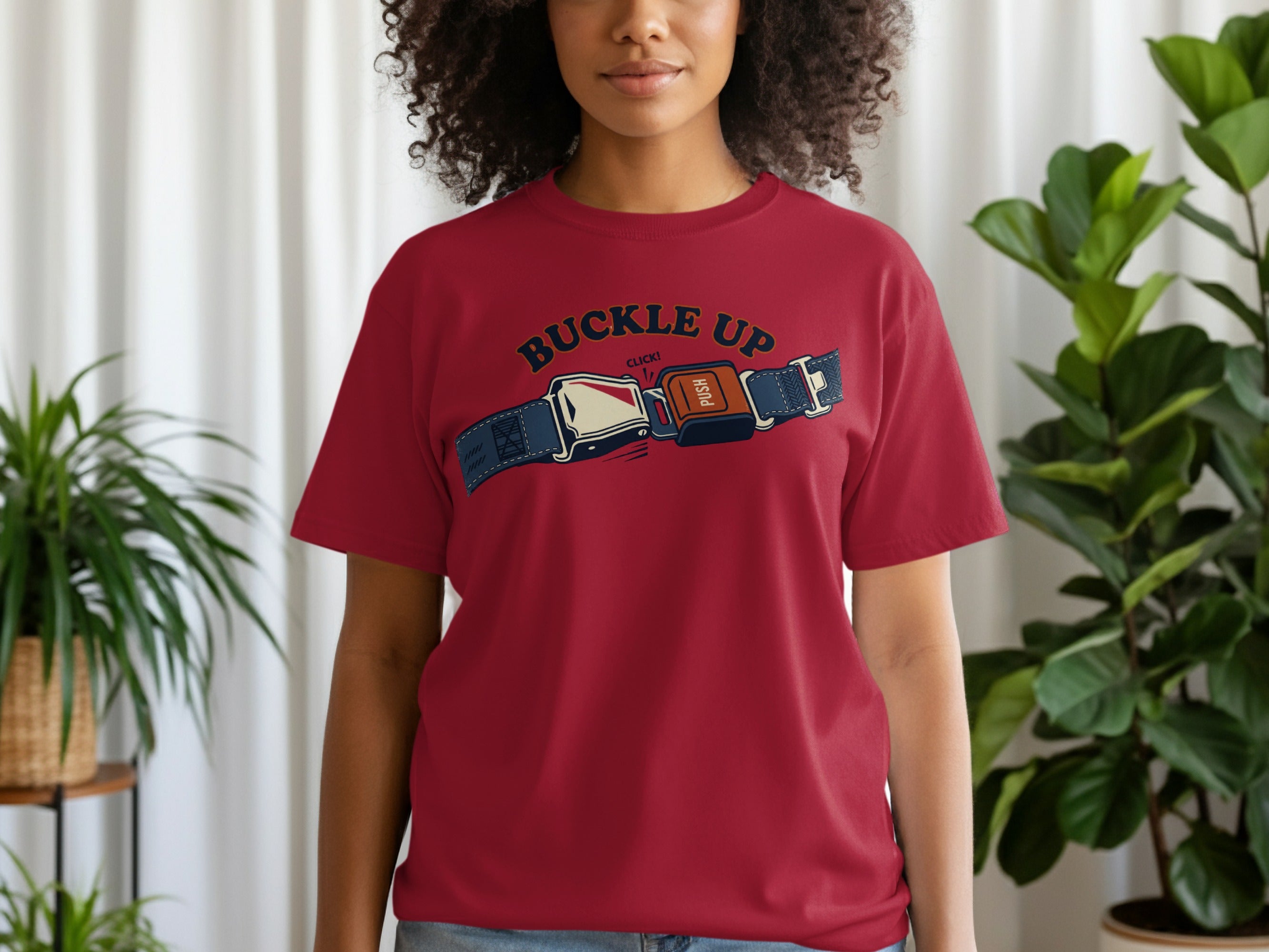 Woman wearing a red t-shirt with a seatbelt graphic.